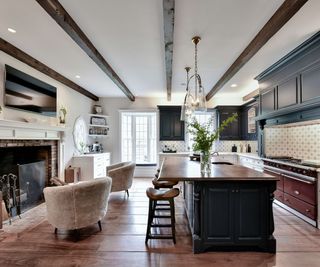 ralph lauren style navy shaker kitchen with large island and a huge fireplace