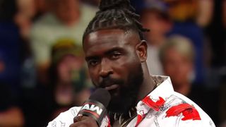 Oba Femi speaks into a microphone on Monday Night Raw.