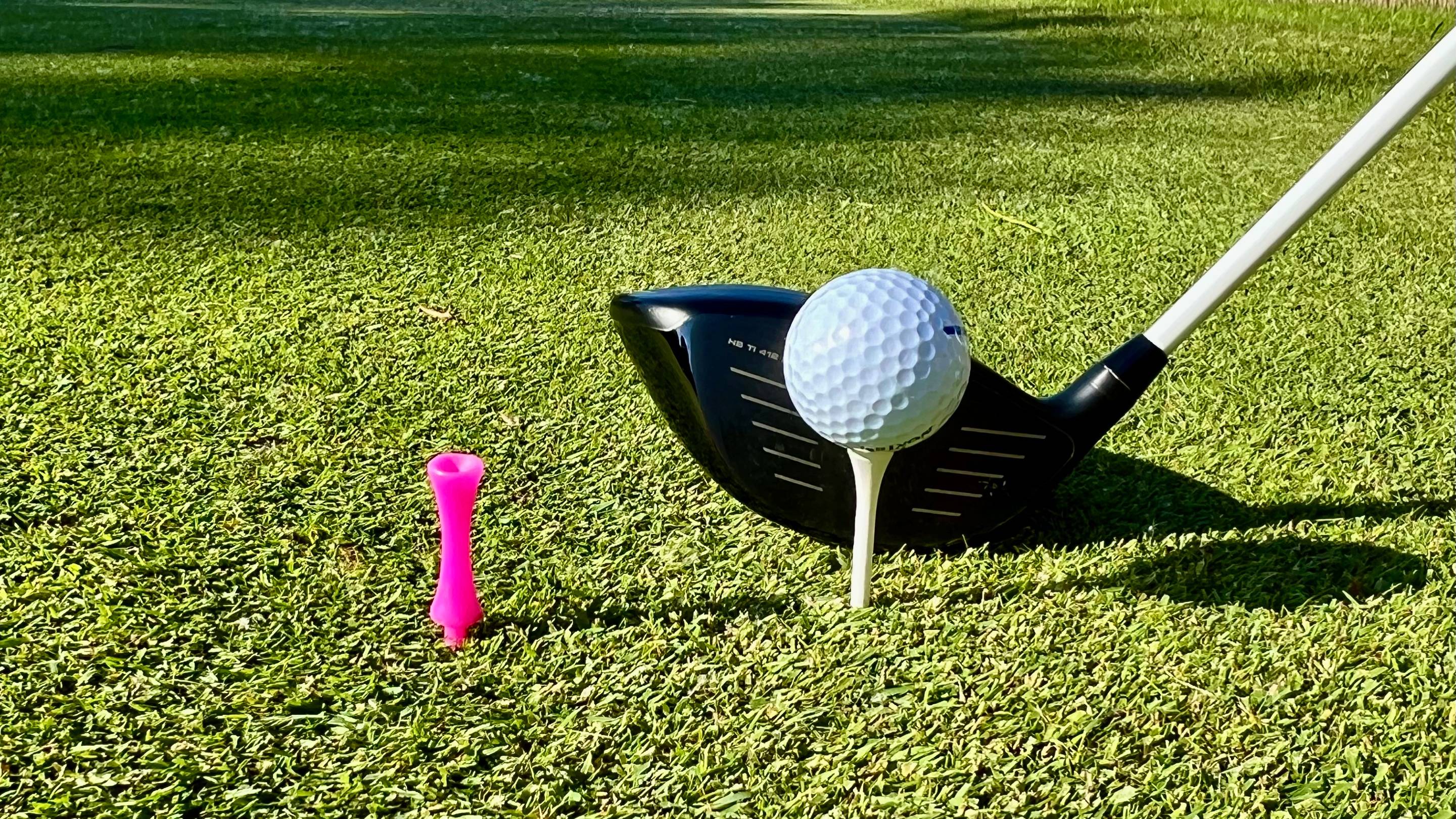 Two different tee pegs with a driver
