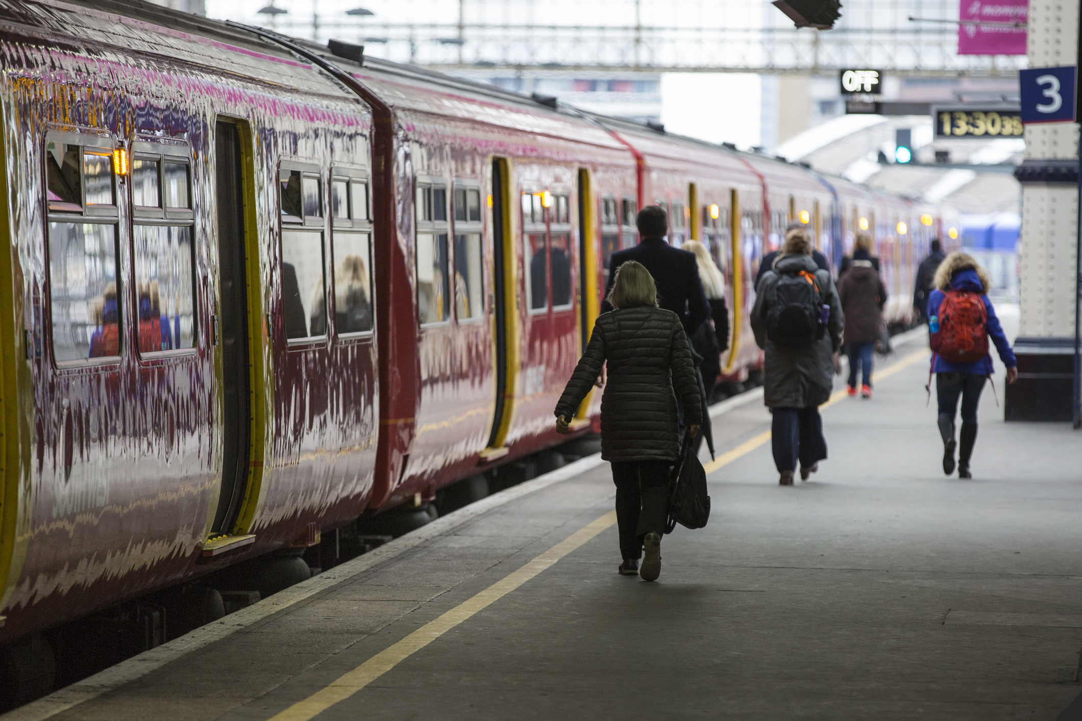 People walking down a train platform