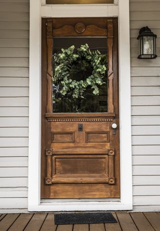 beautiful antique wooden front door with an eucalyptus wreath