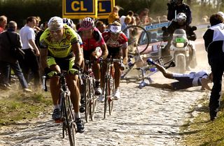 A Fassa-Bortolo and U.S. Postal Service rider crash on the cobbles during the 2003 Paris-Roubaix