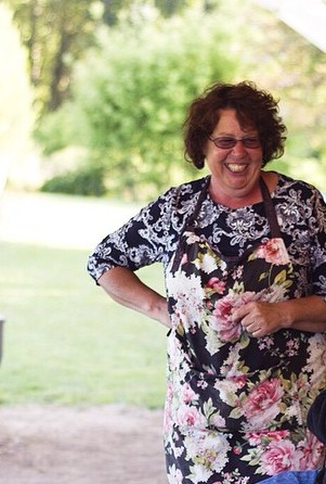 woman wearing floral apron smiling