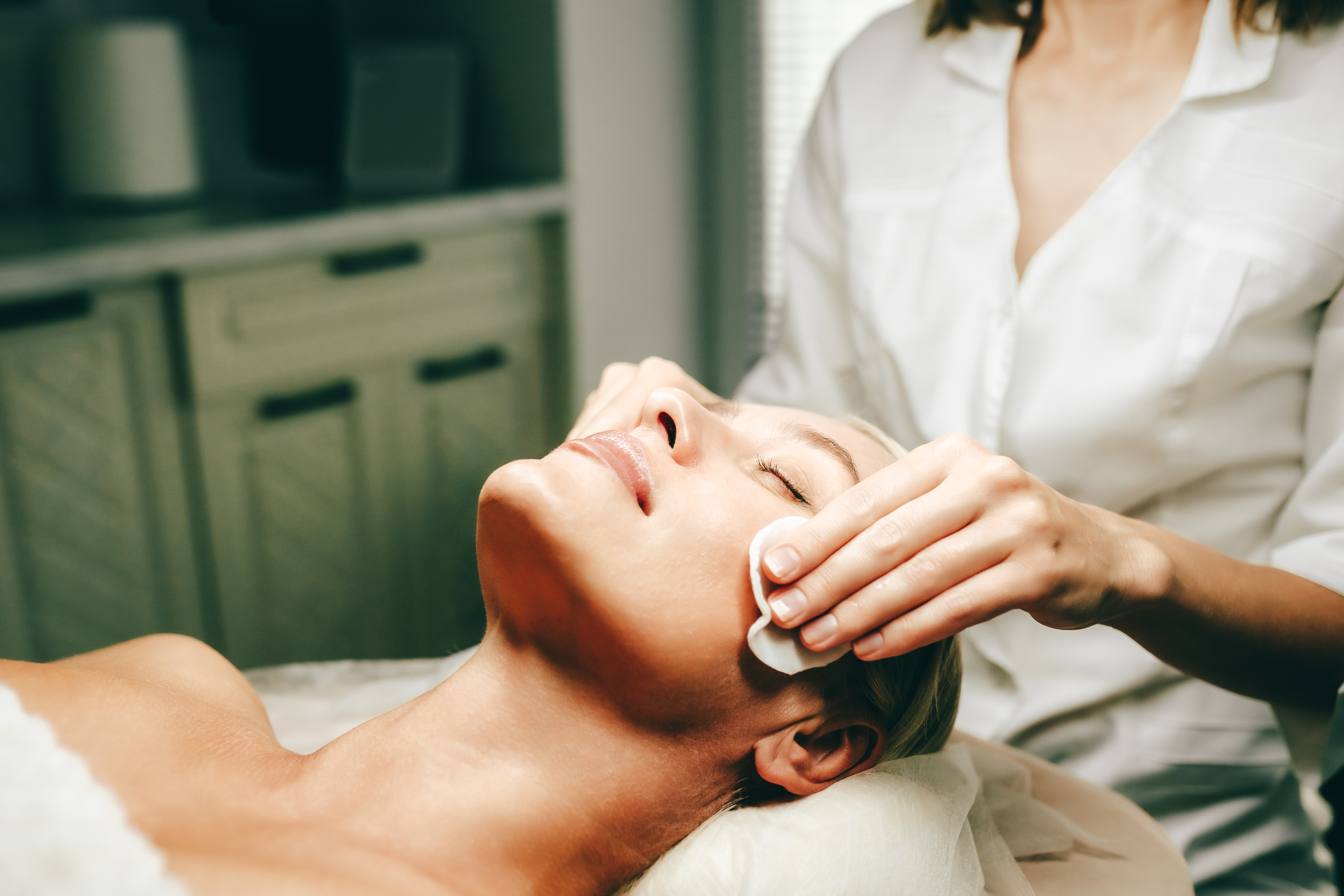 a woman lying down receiving a facial treatment