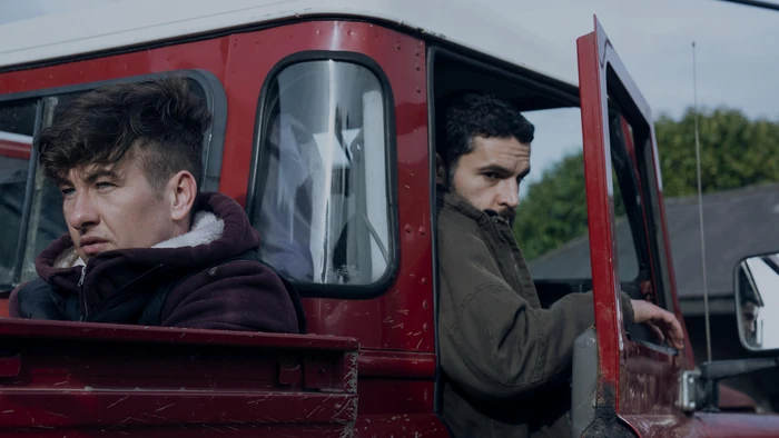 Two male actors in a red truck