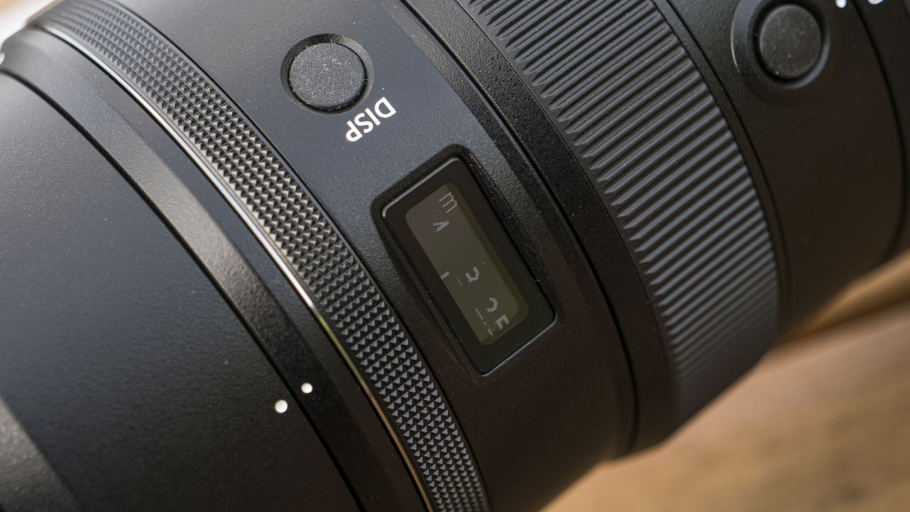 A Nikon Z telephoto lens on a wooden table