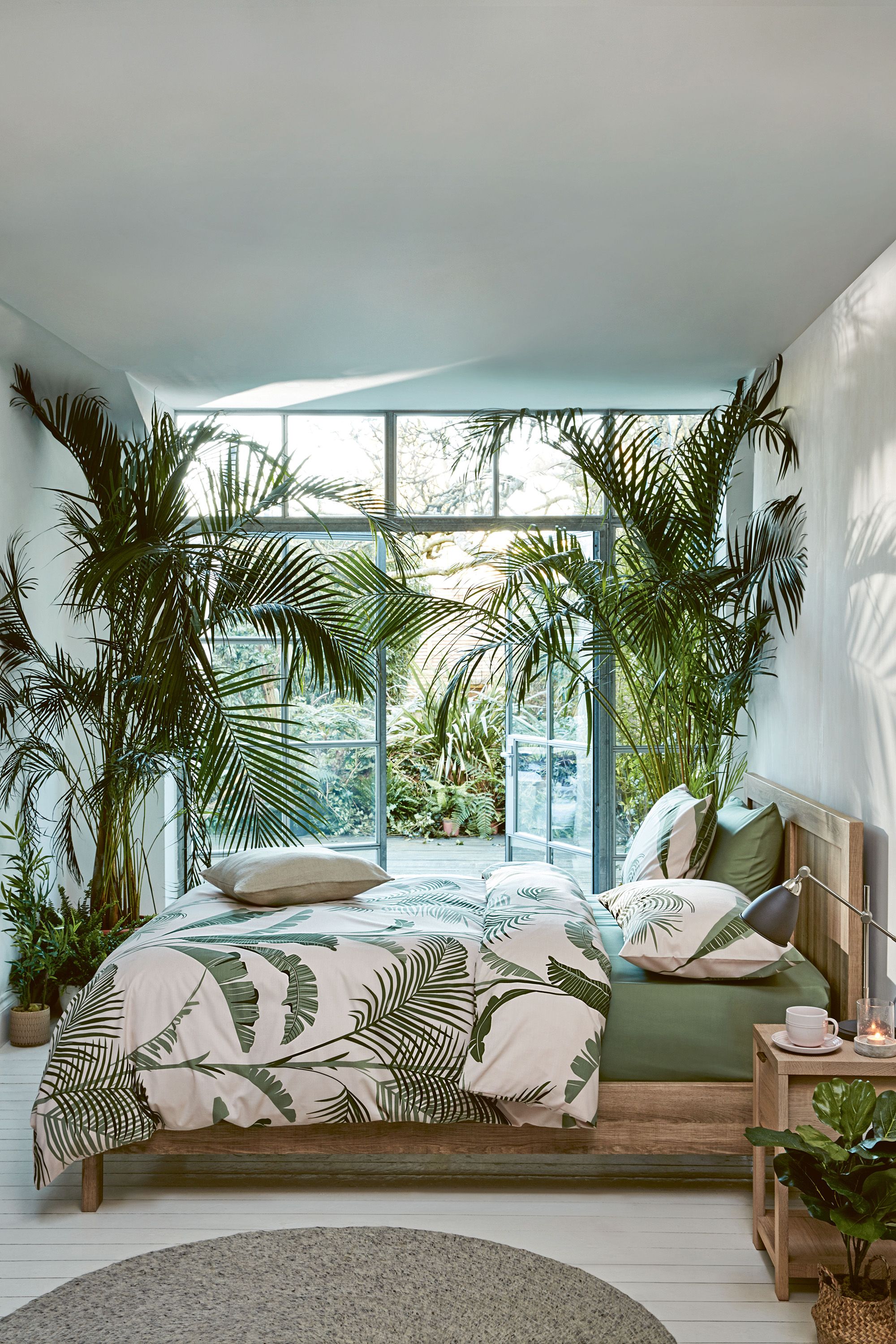 Cameră de dormit care duce prin ușile franțuzești la un spațiu de grădină