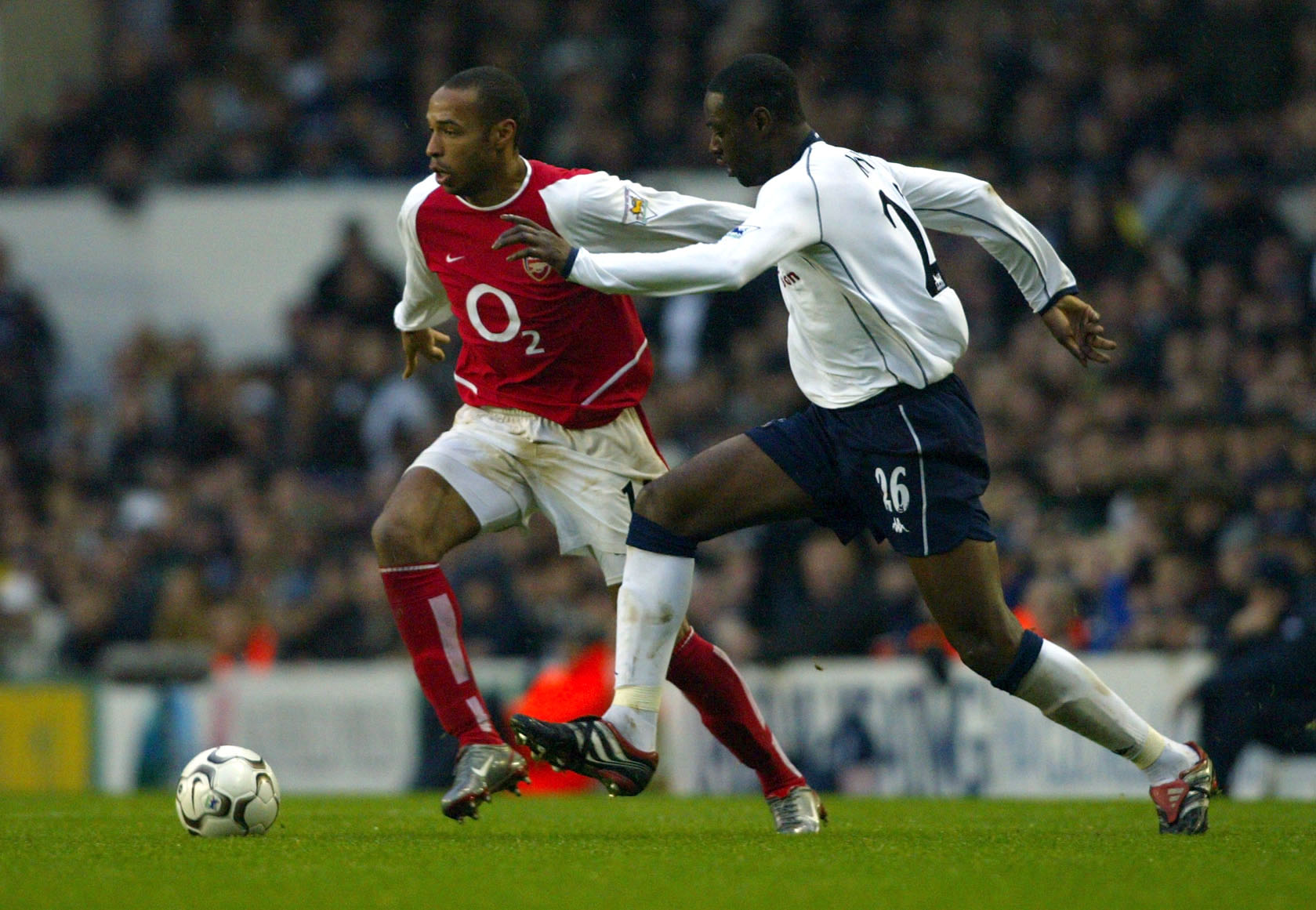 LONDON - DECEMBER 15: Ledley King of Tottenham Hotspur tries to tackle Thierry Henry of Arsenal during the FA Barclaycard Premiership match between Tottenham Hotspur and Arsenal at White Hart Lane, London on December 15, 2002. (Photo by Ben Radford/Getty Images)