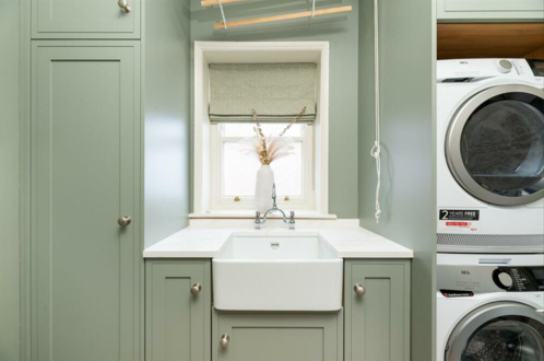 A utility room with a sink and lime green cabinets