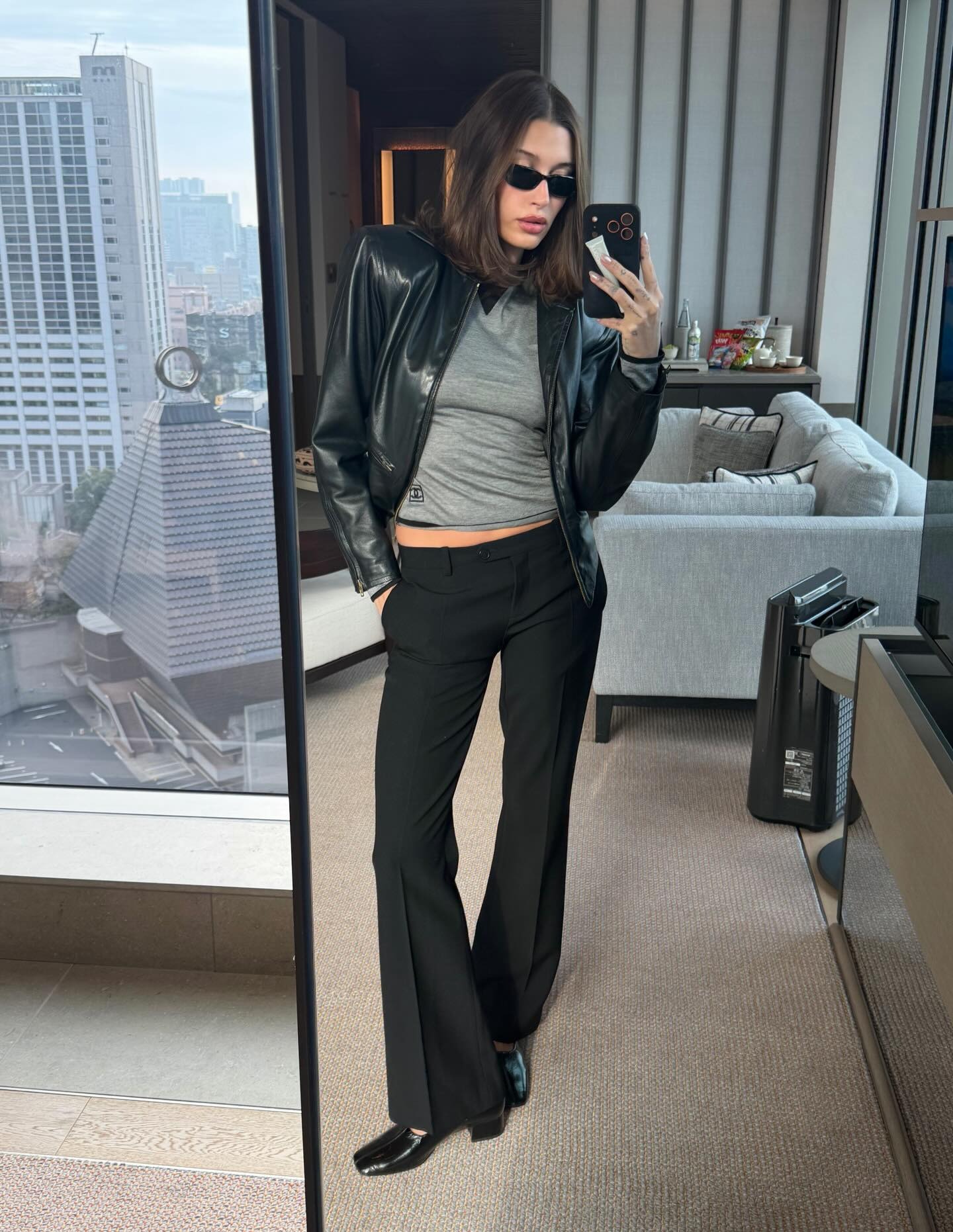 Hailey Bieber wears a coat with pants and the Reformation Inez Pumps.