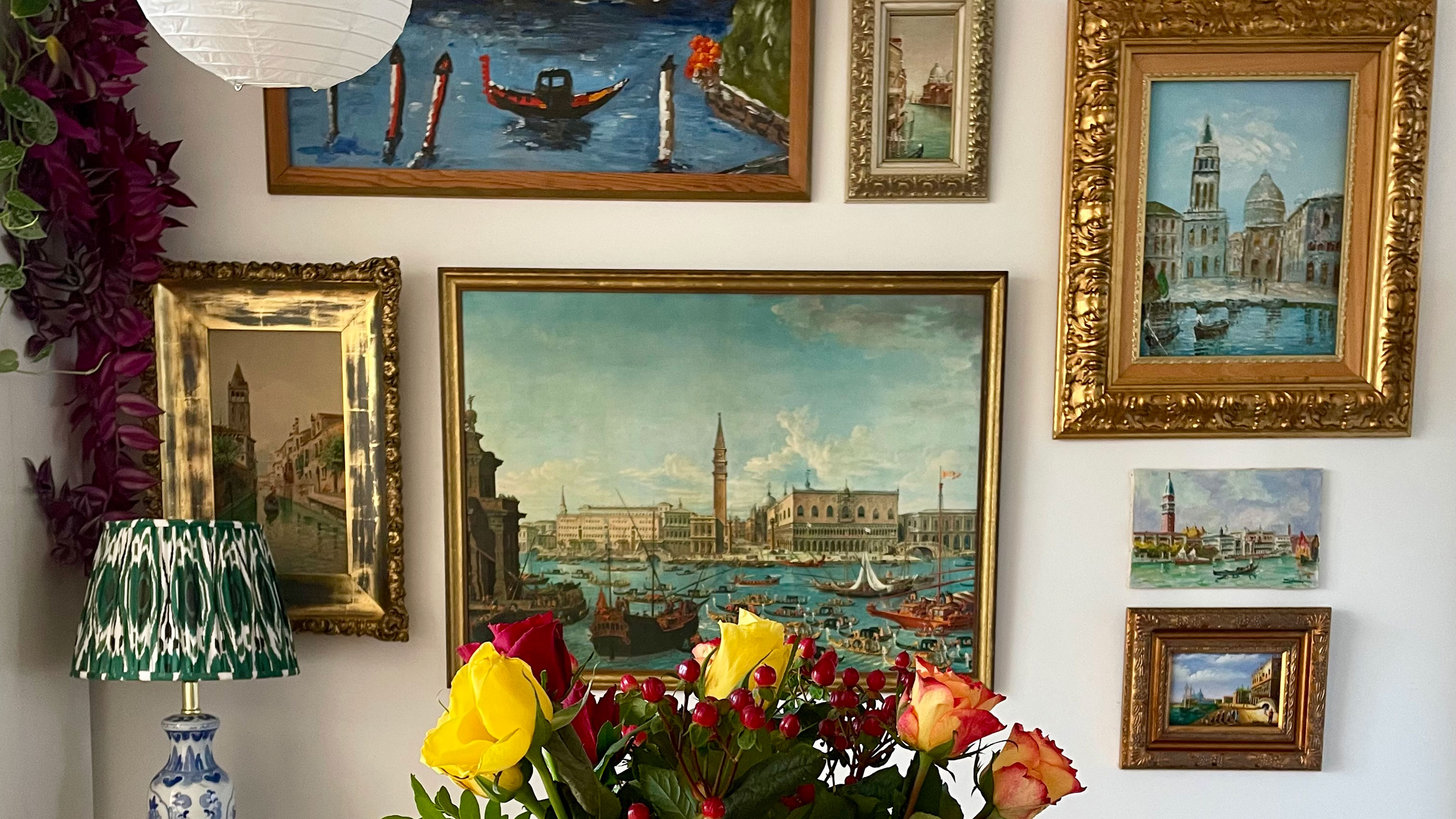 Gallery wall of vintage paintings in traditional frames