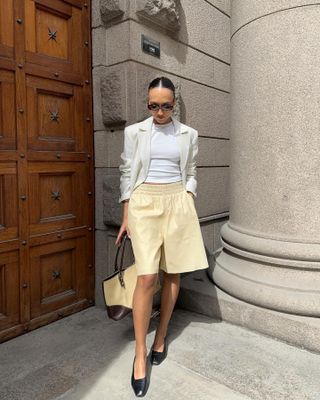 Influencer wears long shorts and ballet flats.