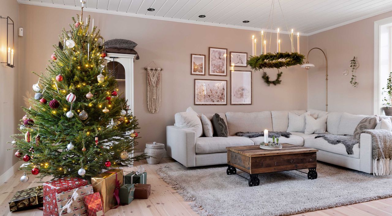 christmas living room with decorated tree, neutral decor and corner sofa