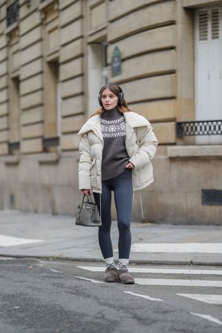 woman wearing puffer jacket, fair isle sweater, leggings, and sneakers