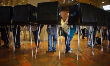 Early voters fill out their ballots for the presidential election on Oct. 27 in Miami: In some states affected by Superstorm Sandy, early voting has been partially disrupted because of the st