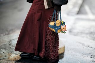 a woman at paris fashion week with a hello kitty bag charm