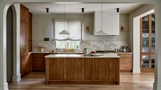 A japandi kitchen with wood cabinets, marble countertops, and textured accessories