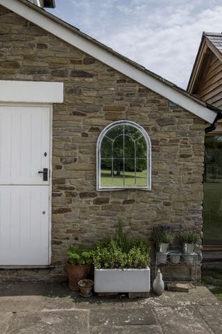 Stone building with mirror and belfast sink outdoors