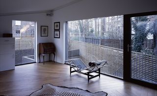 Room in Otts Yard, North london with white walls and large frameless windows