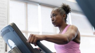 Senior woman using a cross trainer at the gym