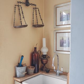 Yellow kitchen with butler sink, art, and wall hangings.