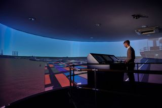 A person looks out aship simulation center with imagery on displays from ST Engineering Antycip.