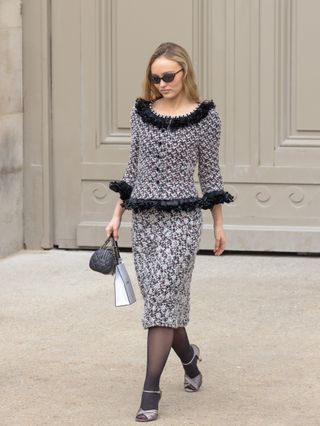 Lily-Rose Depp wears open-toe sandals and tights.