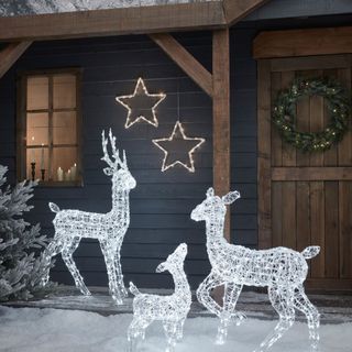 Front of house with lit up reindeer statues.