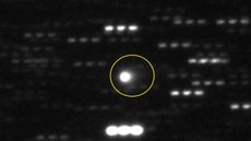 A blurry photo of a comet in the sky with a ring around it