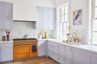 A kitchen in purple tones, with a terrazzo backsplash