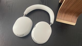 Sonos Ace headphones in soft white finish lying flat on a table