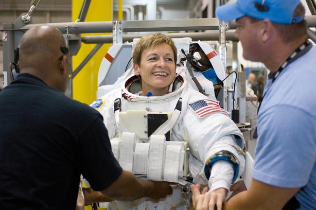 Astronaut Peggy Whitson, Expedition 16 commander, dons a training version of the Extravehicular Mobility Unit (EMU) space suit prior to being submerged in the waters of the Neutral Buoyancy Laboratory (NBL) near the Johnson Space Center.