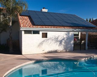pool with solar panels on nearby roof