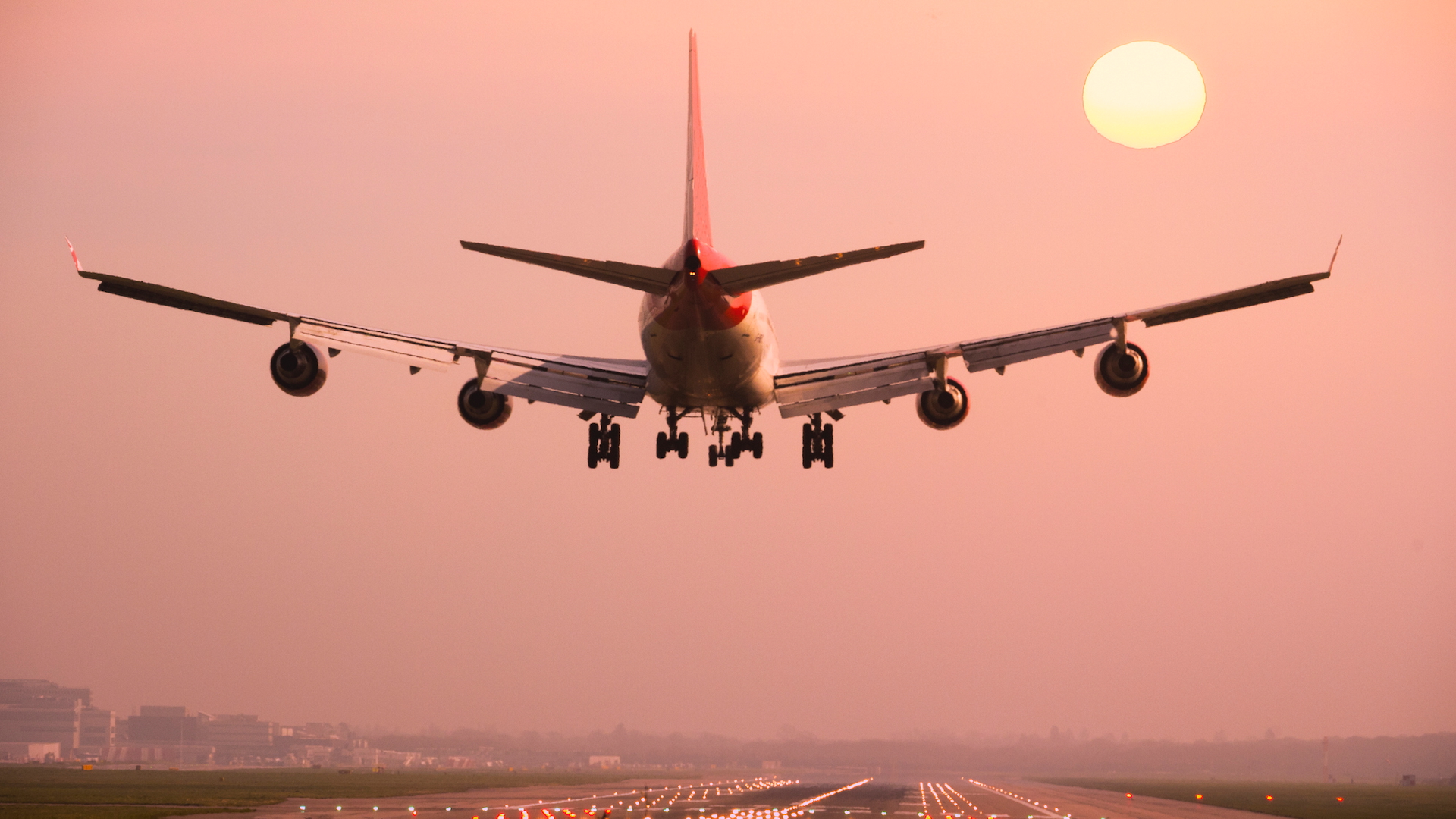 A plane comes in to land at sunset