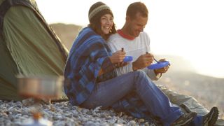 how to keep your tent clean while camping: couple eating outside