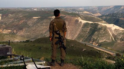 An Israeli soldier stands at a lookout point in the Israel-annexed Golan Heights overlooking south Syria