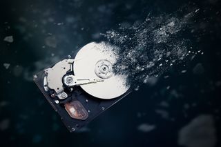 Stock image of a hard drive breaking into small pieces.