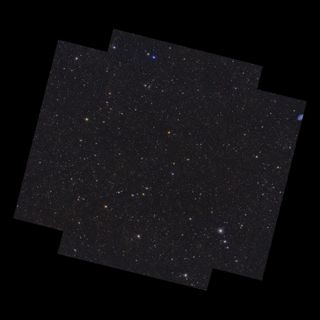 On a black background lies an almost square shape with notches cut out of its corners, oriented with its upper and lower edges sloping slightly from top left to bottom right. Contained within the shape are 4.5 million galaxies, and stars of various size, brightness and colour. Some of the brighter stars have diffraction spikes.]