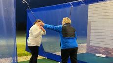 Emma Booth teaching a beginner golfer