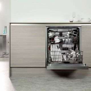 Open door Whirlpool dishwasher loaded with clean dishes