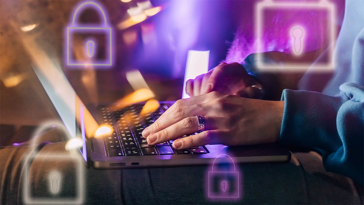 Person typing on a laptop with graphics of padlocks surrounding it 
