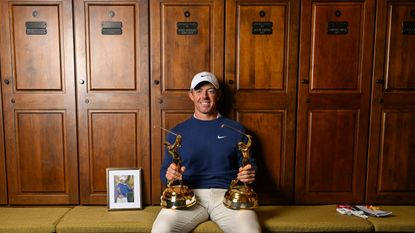 Rory McIlroy sat by his locker at TPC Sawgrass holding his two Players championship trophies