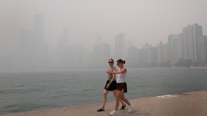 CHICAGO, ILLINOIS - JULY 16: People walk along Lake Michigan as smoke from Canadian wildfires blankets the city on July 16, 2026 in Chicago, Illinois.