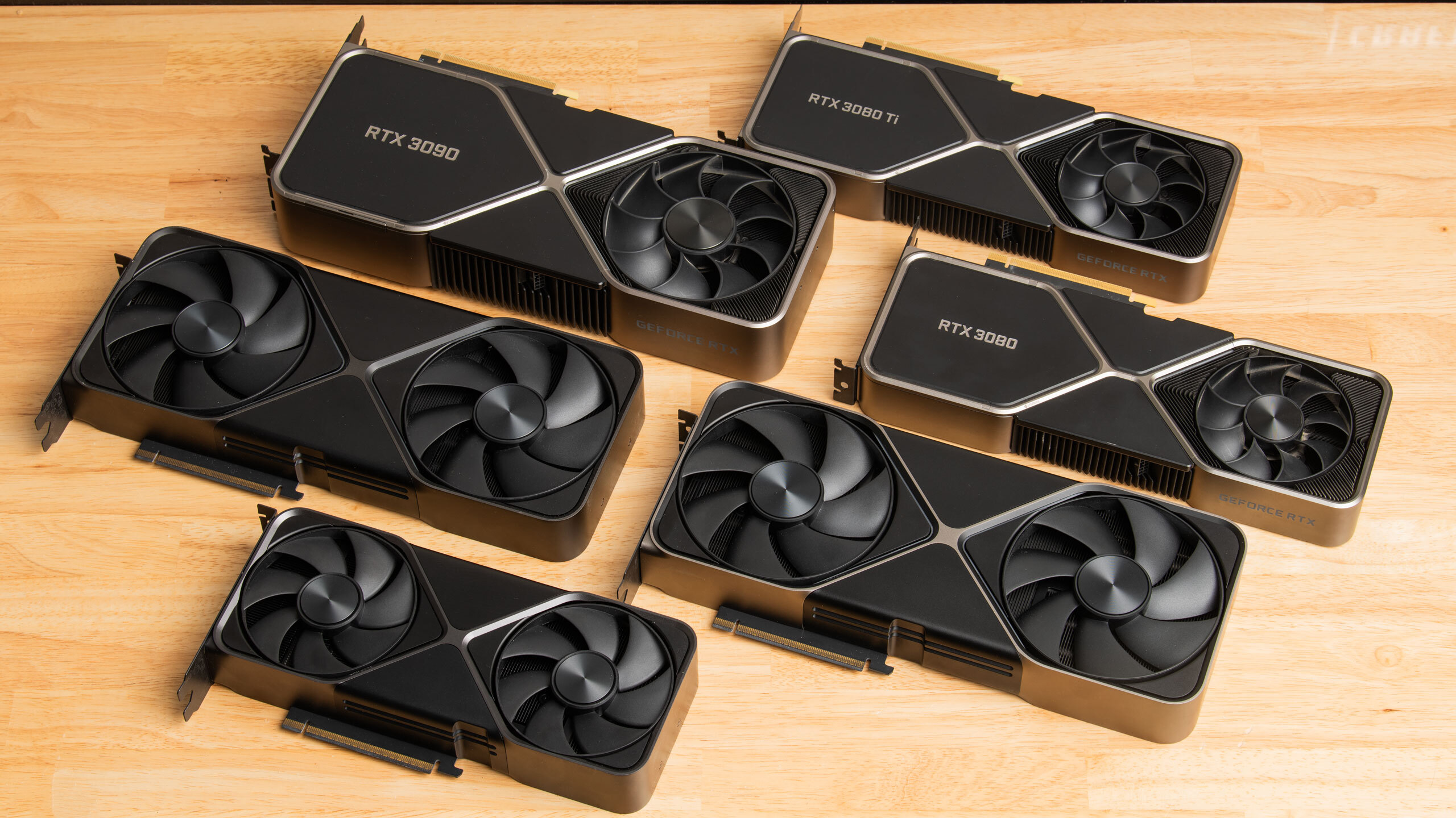 An array of GPUs on a brown desk.