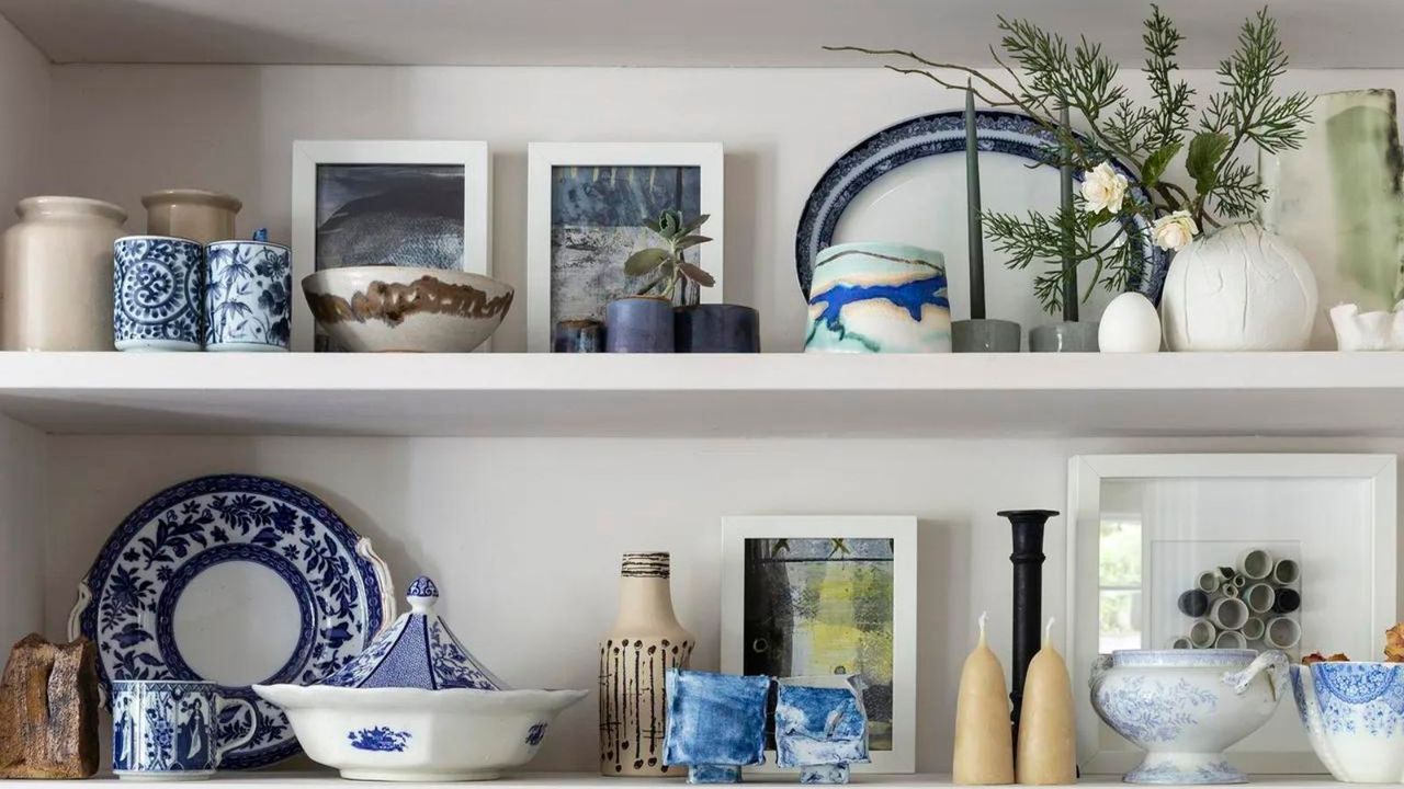 A bookcase filled with curated ceramics and works of art