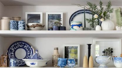 A bookcase filled with various ceramics and works of art