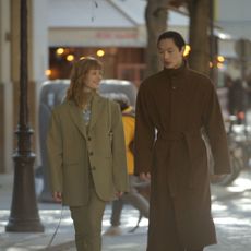 two models in long coats walking in the street