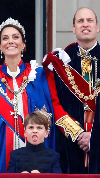 Prince Louis of Wales, Catherine, Princess of Wales (wearing the Mantle of the Royal Victorian Order) and Prince William, Prince of Wales (wearing the Mantle of the Order of the Garter) watch an RAF flypast from the balcony of Buckingham Palace following the Coronation of King Charles III & Queen Camilla at Westminster Abbey on May 6, 2023 in London, England