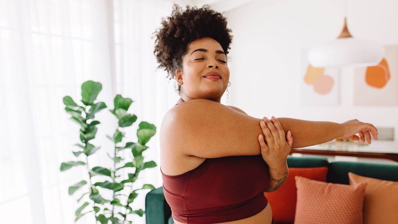 Woman preparing for a home workout by stretching her arms