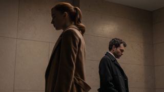 Emily (Phoebe Dynevor) and Luke (Alden Ehrenreich) stand back to back in Fair Play 
